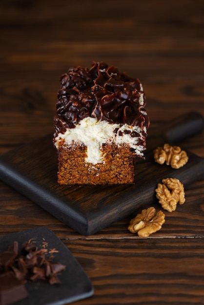 Gâteau à la carotte au dessert avec du fromage à la crème à la vanille, du chocolat et des noix.