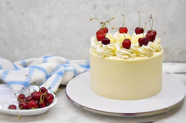 Un gâteau avec des cerises sur le dessus et un bol de cerises sur le côté