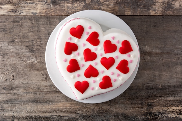 Gâteau coeur pour la Saint-Valentin, décoré de coeurs en sucre sur table en bois