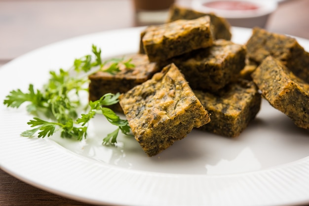 Le gâteau à la coriandre ou Kothimbir Vadi est une cuisine maharashtrian populaire à base de feuilles de coriandre. servi avec du ketchup aux tomates. mise au point sélective