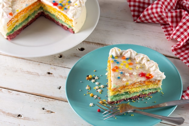 Gâteau de couche arc-en-ciel sur table en bois blanc