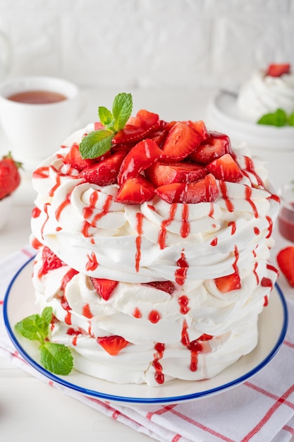 Gâteau en couches de pavlova avec sauce aux fraises fraîches et crème fouettée Beau gâteau d'été