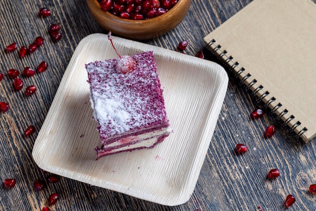 Un gâteau de couleur marron avec le goût de différentes baies et une garniture au lait crémeux de fromage cottage avec des graines de grenade