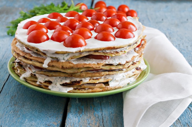 Gâteau de courgettes à la tomate et au persil sur un bois bleu