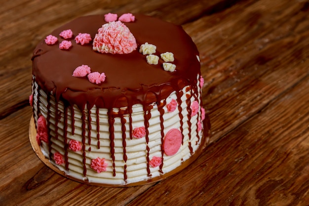 Gâteau à la crème et au chocolat avec des roses sur l&#39;ancien tableau