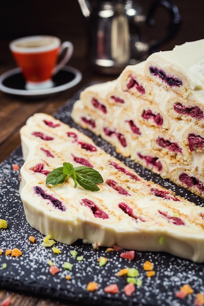 Gâteau à la crème et aux cerises et tasse de cafégâteau savoureux à la crème blancheGâteau russe nommé Monastyrskaya izba Cabane du monastère aux cerises