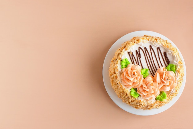 Gâteau à La Crème De Biscuits Avec Des Roses Crémeuses Sur La Plaque Blanche