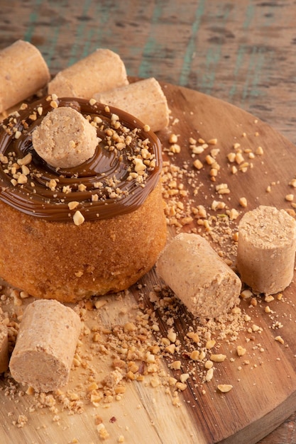 Gâteau à la crème dulce de leche avec pacoca et cacahuètes sur planche de bois sous portrait de table rustique dans le jardin à l'extérieur de fond d'herbe