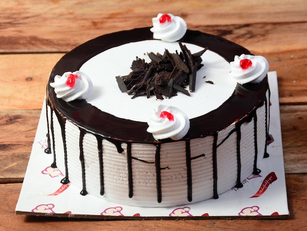 Gâteau à la crème de forêt noire fraîchement préparé sur une table en bois mise au point sélective