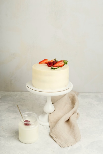 Gâteau à la crème avec des fraises fraîches pour des vacances, fond clair