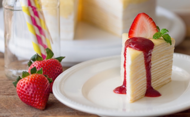 Gâteau de crêpe fait maison et sauce aux fraises décore menthe et fraise fraîche