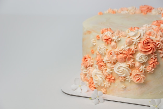Gâteau avec décoration de fleurs crème.