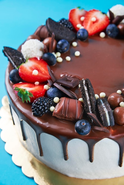 Gâteau décoré de fraise et de chocolat sur fond bleu