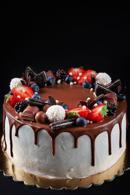 Gâteau décoré de fraise et de chocolat sur fond sombre