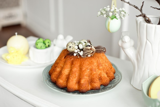 Gâteau décoré d'oeufs et de plumes sur une assiette