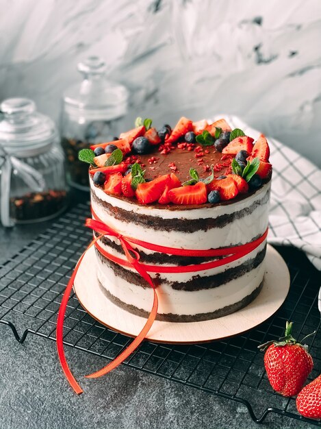 Gâteau délicieux et juteux fait maison décoré de fraises et de baies vivantes