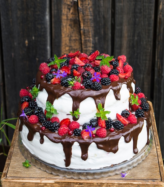 gâteau à deux niveaux avec des fruits et des fleurs. Dessert. Forêt noire