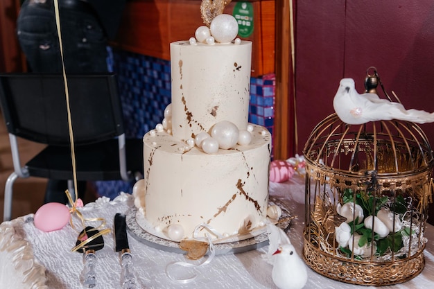 Gâteau à deux niveaux de mariage Goldenwhite sur la table