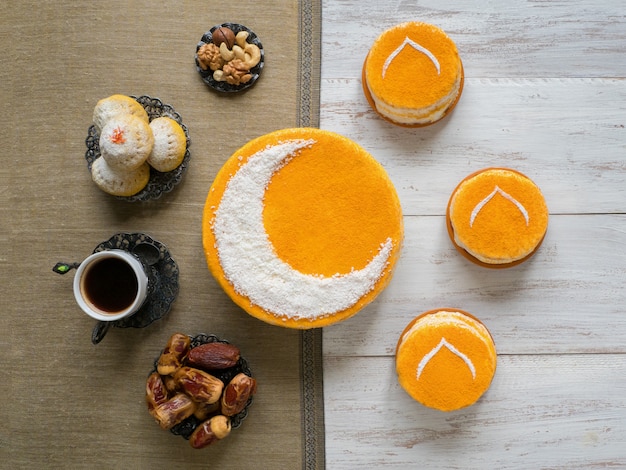 Gâteau doré fait maison avec un croissant de lune, servi avec du café noir et des dattes