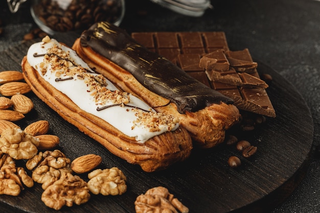 Gâteau Eclair sur planche de bois sombre sur table noire