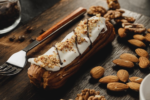 Gâteau Eclair sur planche de bois sombre sur table noire