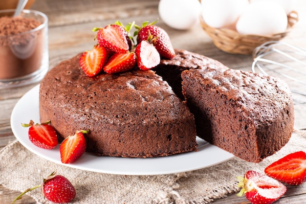 Gâteau éponge au chocolat avec fraise sur une table en bois