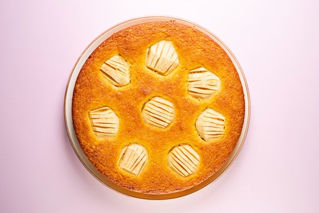 Gâteau éponge aux pommes sur une plaque en bois.