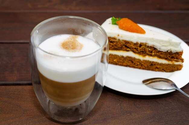 Gâteau à l'éponge à la carotte avec de la crème et des noix et du café cappuccino