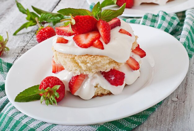 Un gâteau d'éponge avec de la crème et des fraises