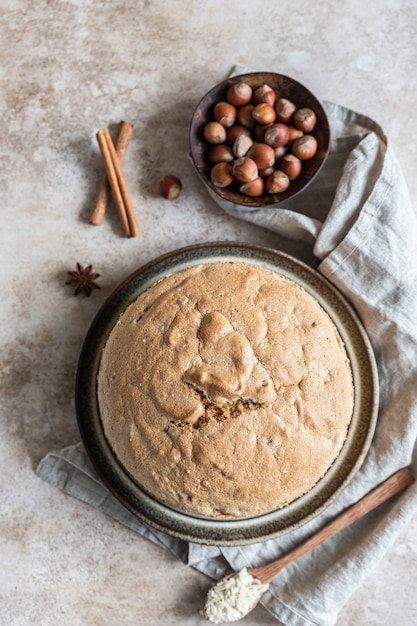 Gâteau éponge fait maison avec des noix et des épices, fond de béton. Mise au point sélective. Vue de dessus.