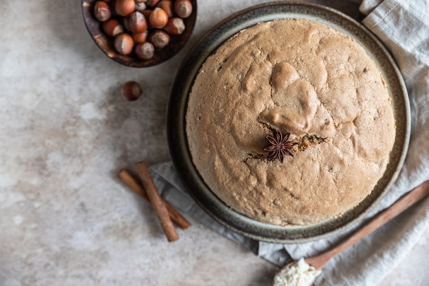 Gâteau éponge fait maison avec des noix et des épices, fond de béton. Vue de dessus.