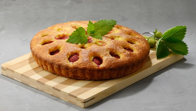 Gâteau éponge rond aux fraises sur planche de bois