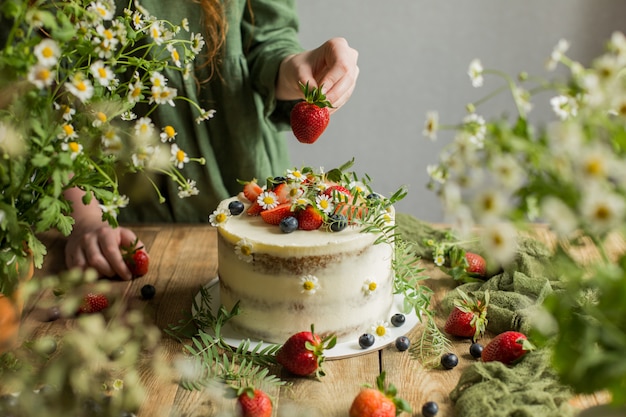 Le gâteau est décoré de baies et de fleurs