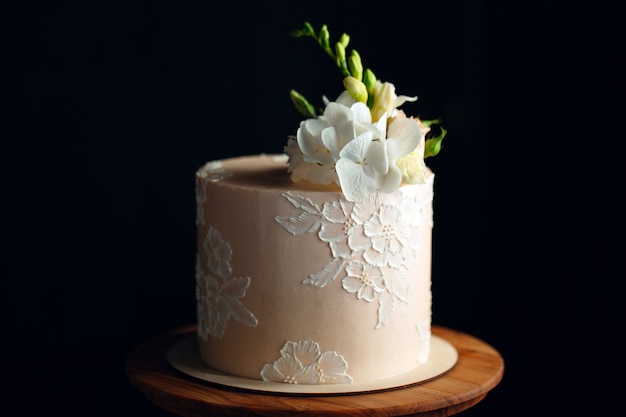 Le gâteau est décoré de fleurs dans le noir