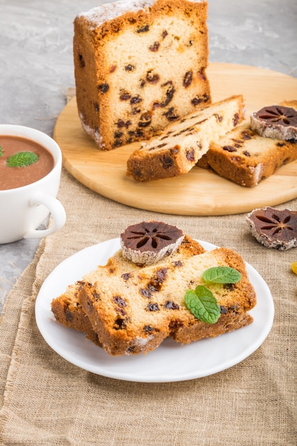 Gâteau fait maison aux raisins secs, kaki séché et une tasse de chocolat chaud sur un fond de béton gris. vue de côté.