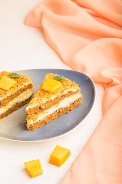 Gâteau fait maison avec kaki et citrouille sur un fond en bois blanc avec textile orange. vue latérale, mise au point sélective.