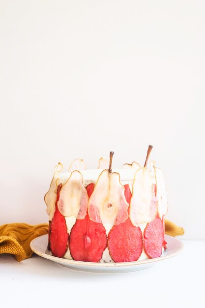 Gâteau de fête blanc décoré de tranches de poires rouges et blanches