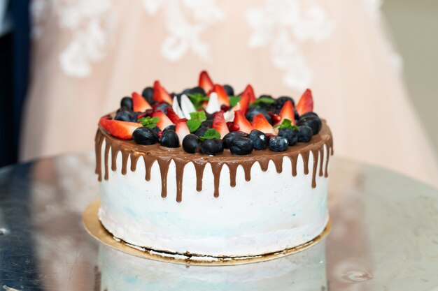 Gâteau de fête rond avec des baies fraîches et du chocolat