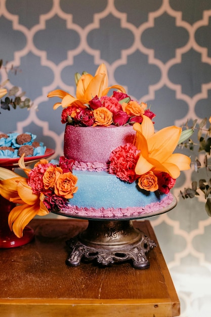 Photo un gâteau avec des fleurs dessus est décoré d'un ruban bleu