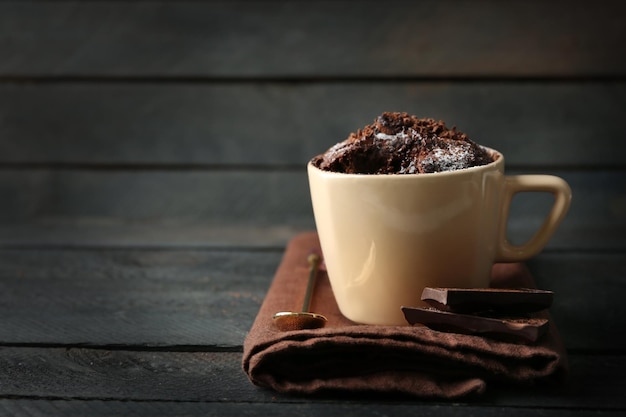 Gâteau fondant au chocolat dans une tasse sur fond de bois