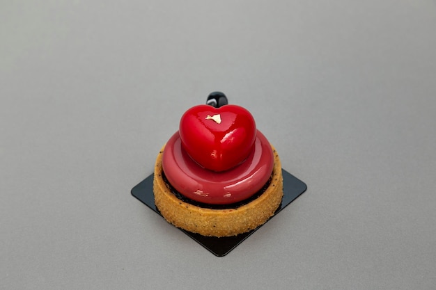 Un gâteau en forme de coeur rouge avec un coeur rouge sur le dessus.