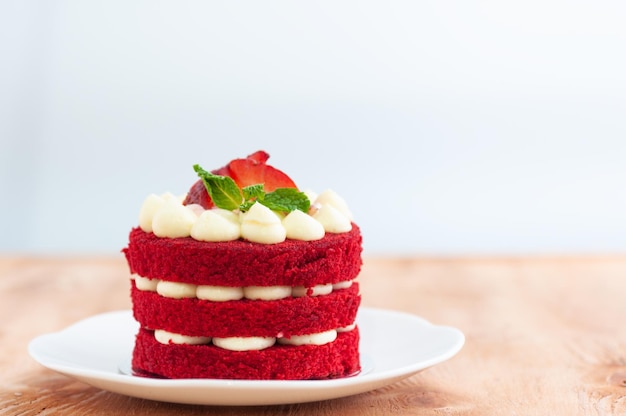 Photo gâteau à la fraise avec des couches de chocolat blanc et une tranche de fraise fraîche surmontée de menthe