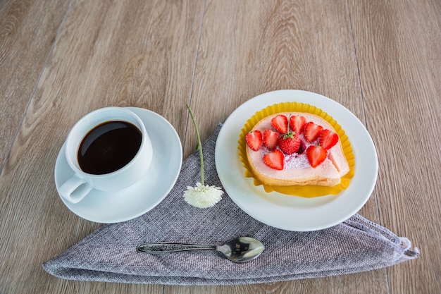 Gâteau et fraises sur fond de bois