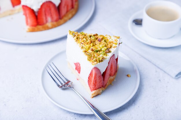 Gâteau freesier aux fraises fraîches et pistaches. Dessert classique français. Portion de gâteau sur un gros plan de plaque blanche.