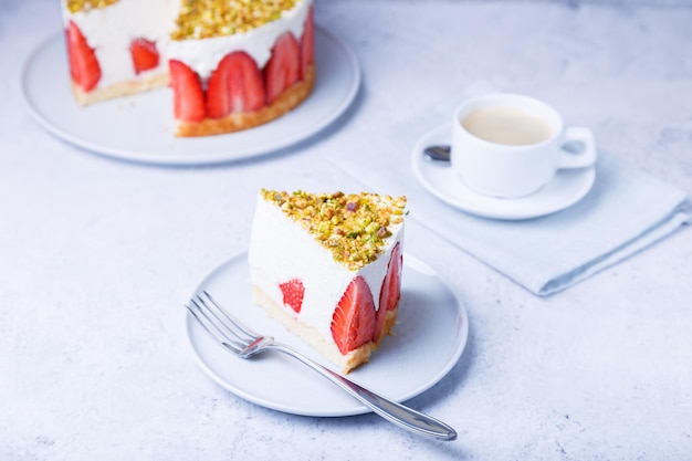 Gâteau freesier avec fraises fraîches et pistaches Dessert classique français Portion de gâteau sur une plaque blanche en gros plan