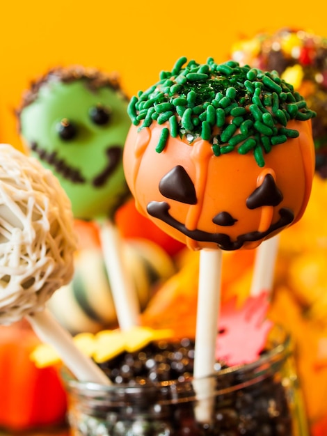 Photo le gâteau gastronomique d'halloween apparaît avec un décor de vacances sur fond orange.