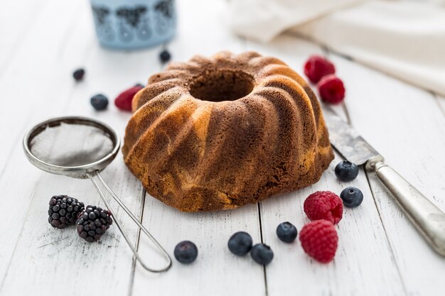 Gâteau. Gâteau en marbre tasse de café en poudre sucre ustensile de cuisine vintage et baies de fruits frais.