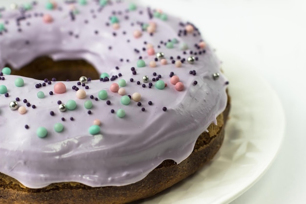 Gâteau avec glaçage de couleur lavande sur fond blanc