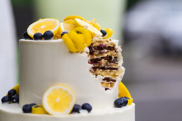 Gâteau grignoté joliment décoré sur un stand lors d'une cérémonie de mariage à l'extérieur