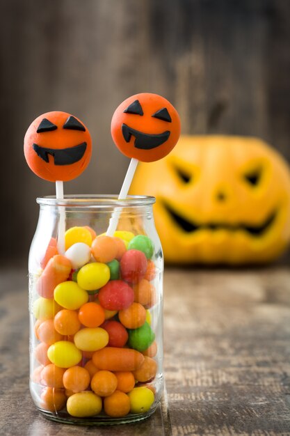 Gâteau d'Halloween apparaît et bonbons colorés sur un mur en bois rustique